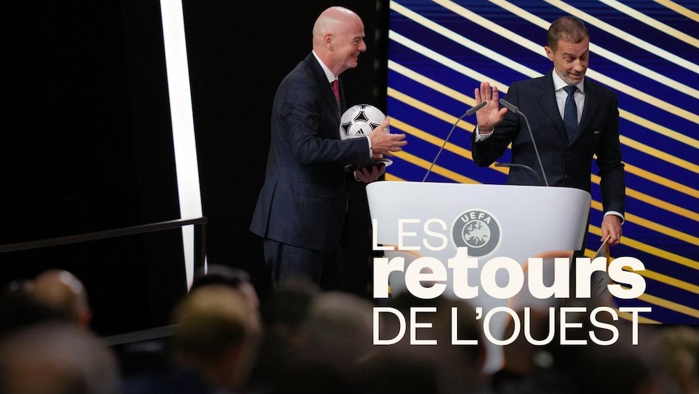 Un homme s'éloigne du lutrin alors qu'un second qui tient un ballon de soccer s'en approche.
