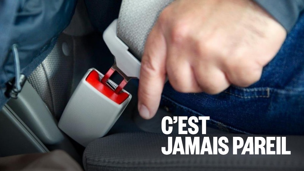 Un conducteur boucle sa ceinture de sécurité. 