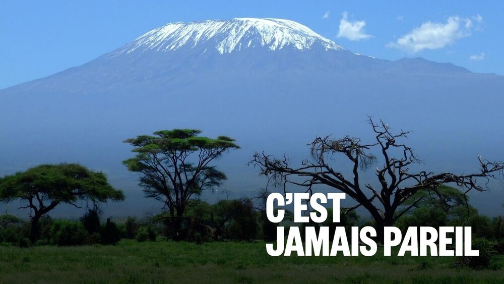 Le Kilimandjaro se dresse sous un ciel partiellement nuageux.
