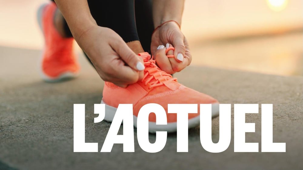 Au soleil couchant, une femme noue les lacets de son soulier de course.