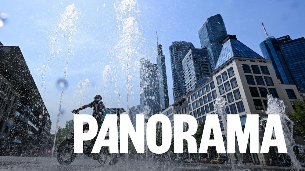 Un homme traverse à vélo une fontaine d'eau.