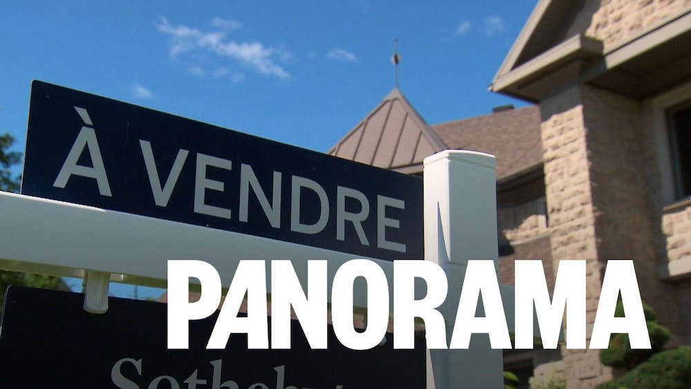 Une pancarte « À vendre » devant une maison de brique.