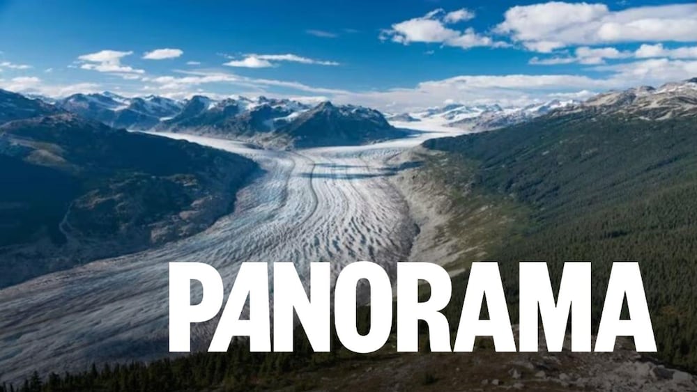 Énorme glacier dans une vallée,avec fond de montagnes.
