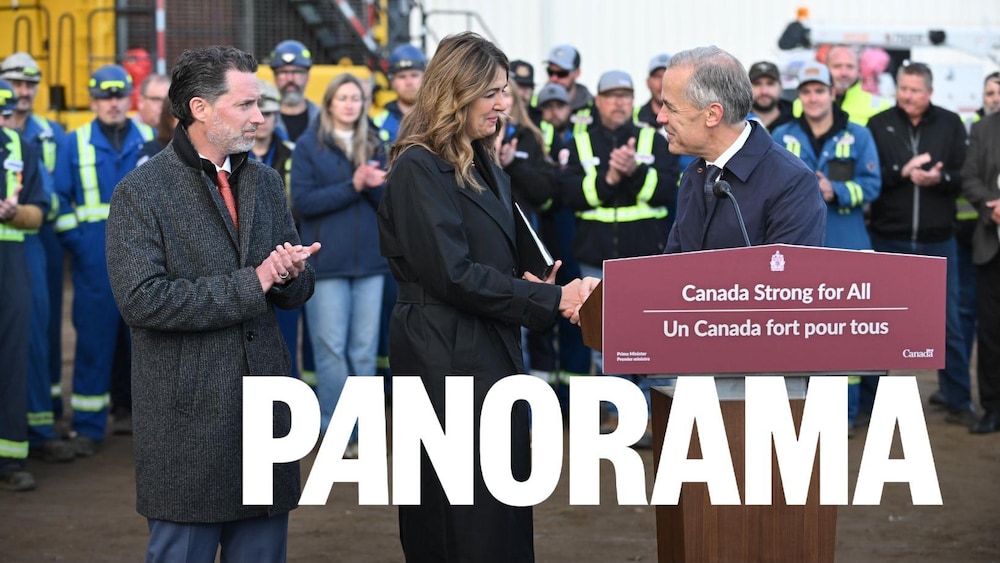 Trois politiciens à côté d'un podium avec des travailleurs industriels rassemblés en arrière-plan.