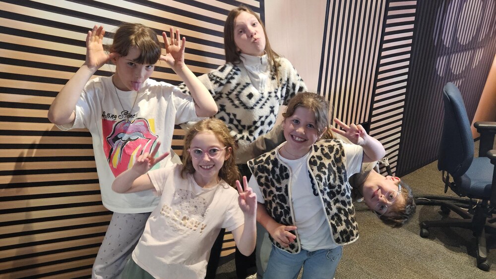 Un groupe d'enfants de six à onze ans font la grimace en studio.