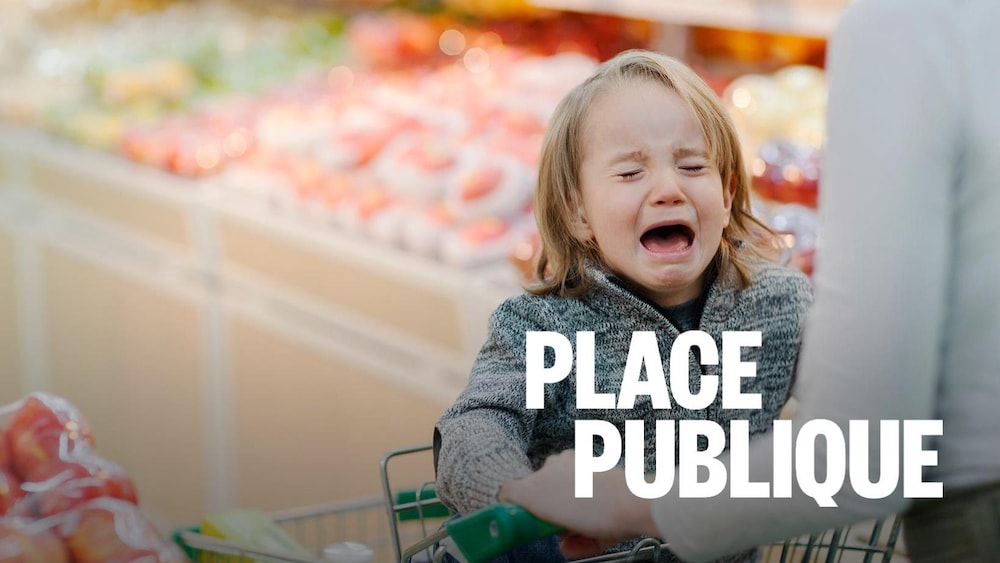 Un jeune enfant dans le chariot pleure fort alors que sa mère essaye de faire son épicerie.