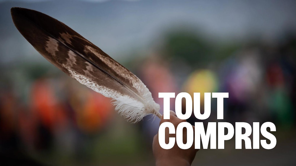 Une femme brandissant une plume d'aigle au passage d'un convoi de camionneurs, en soutien au peuple Tk'emlups te Secwepemc, après la découverte des restes d'enfants enterrés près de l'ancien pensionnat indien de Kamloops, en Colombie-Britannique.
