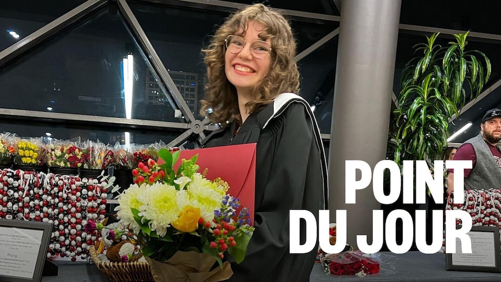 Une personne debout qui tient un bouquet de fleurs.