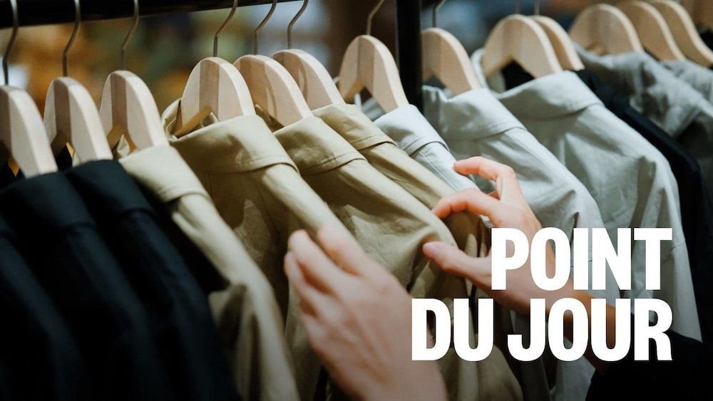 Des mains manipulent des chemises sur des cintres.