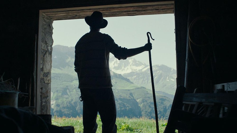 Avec l'autorisation du TIFF Un homme est de dos dans le chambranle d'une porte face à une montagne.