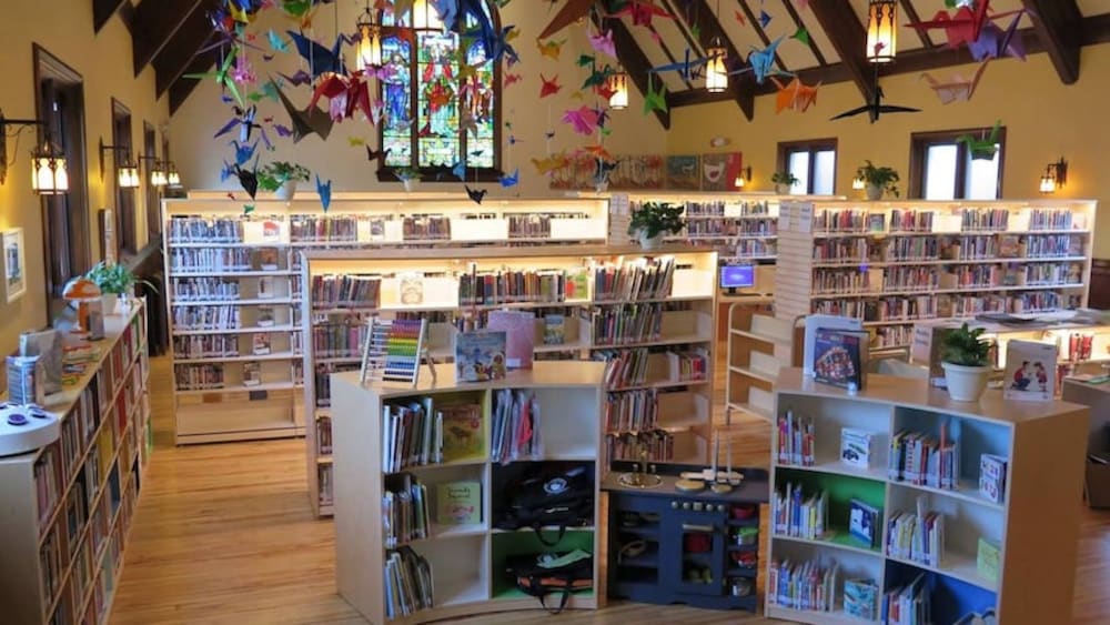 L'intérieur d'une bibliothèque, avec de nombreuses grues en origami accrochées au plafond.