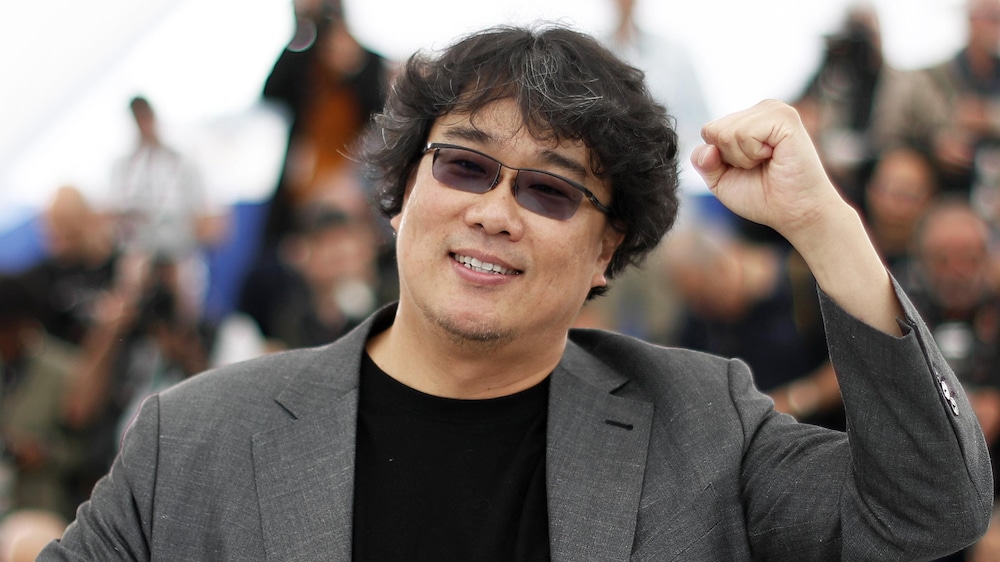 Reuters / Eric Gaillard Le réalisateur du film «Parasite» Bong Joon-ho a le bras levé sur la Croisette.