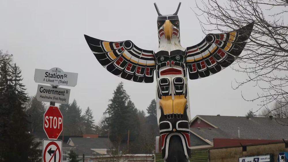 Un totem près d'un panneau de signalisation d'arrêt, près d'une intersection