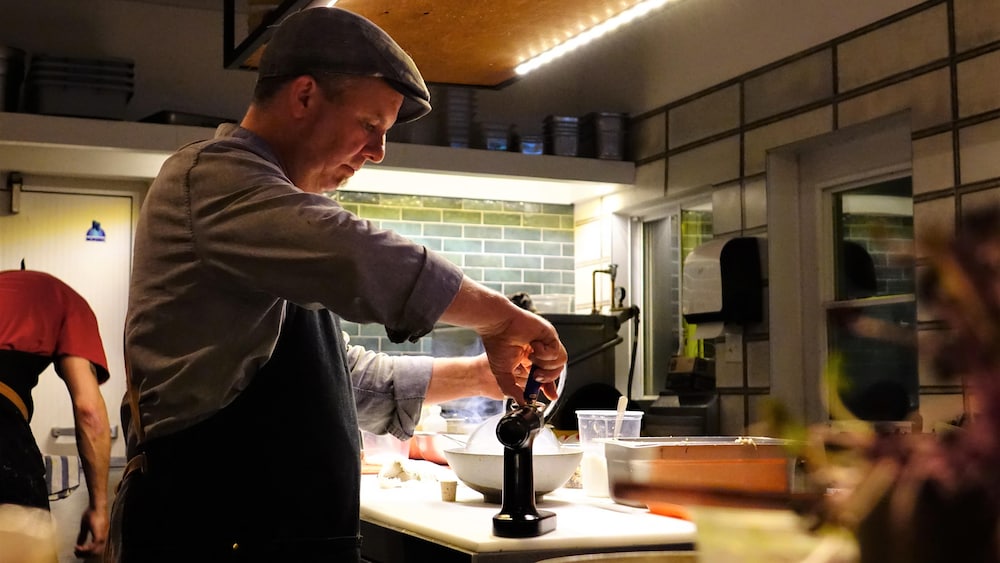 Un cuisinier debout  dans la cuisine d'un restaurant