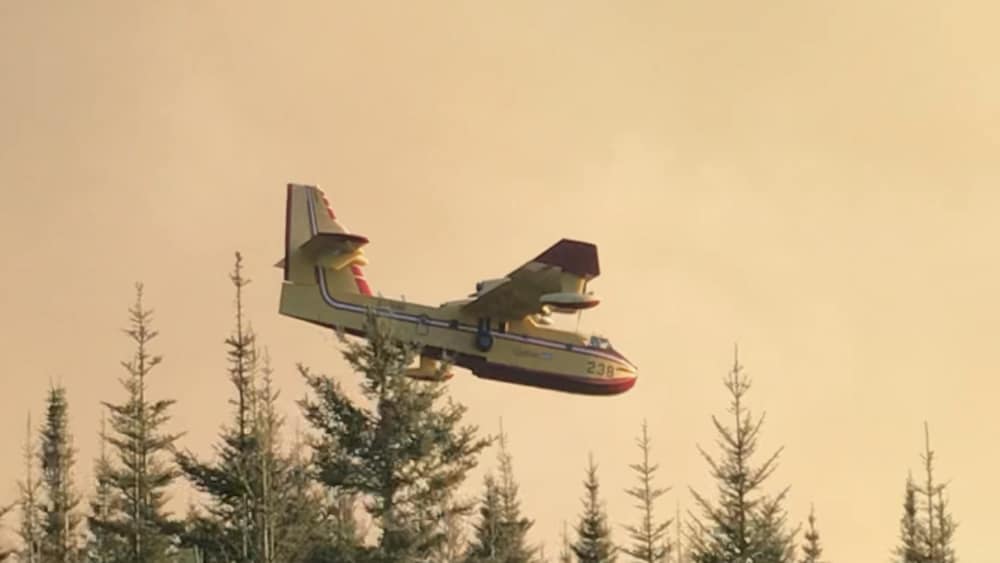 Un avion citerne de la SOPFEU survole le feu en Haute-Gaspésie.