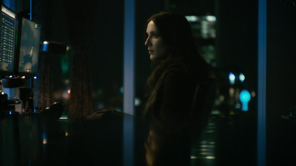 Entract Films / Nemesis Films inc Portrait d'une personne devant des écrans d'ordinateurs.