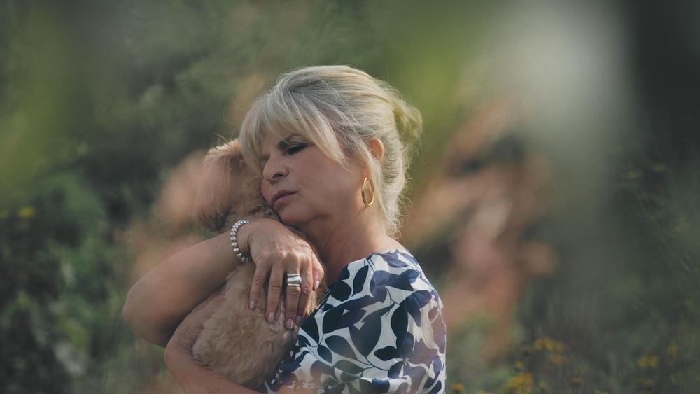 Radio-Canada Une femme serre un chien dans ses bras.