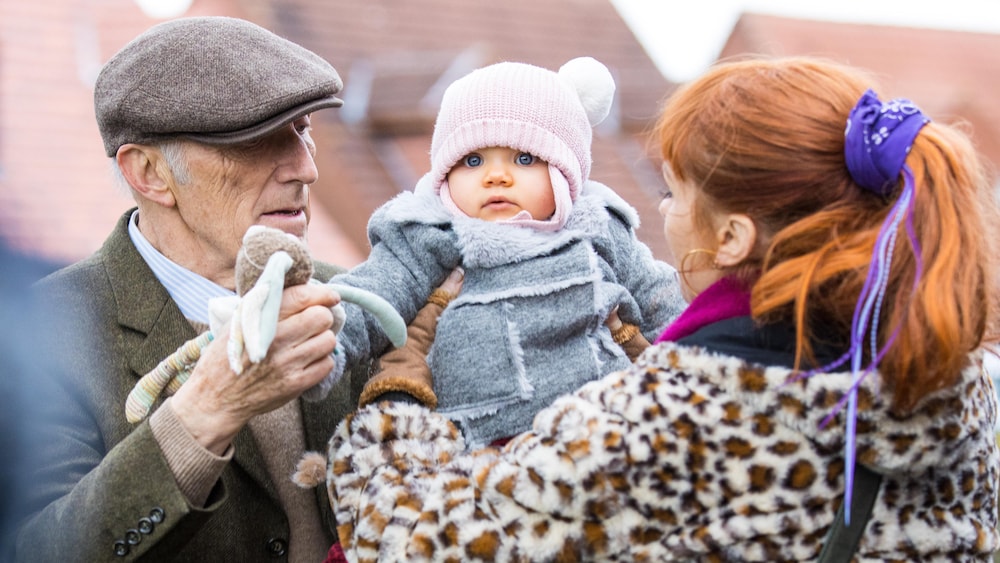 Radio-Canada / Philippe Le Roux/Itinéraire Productions/TF1 Henri et Morgane sont dehors, une petite fille d'un an dans leurs bras.