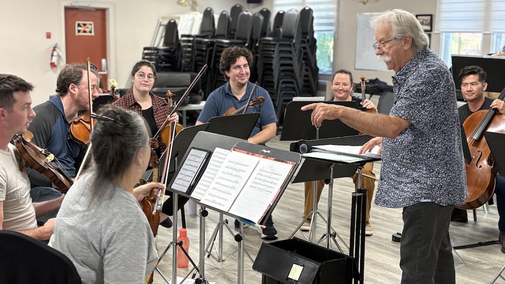 Jacques Marchand dirige des musiciens lors d'une pratique.