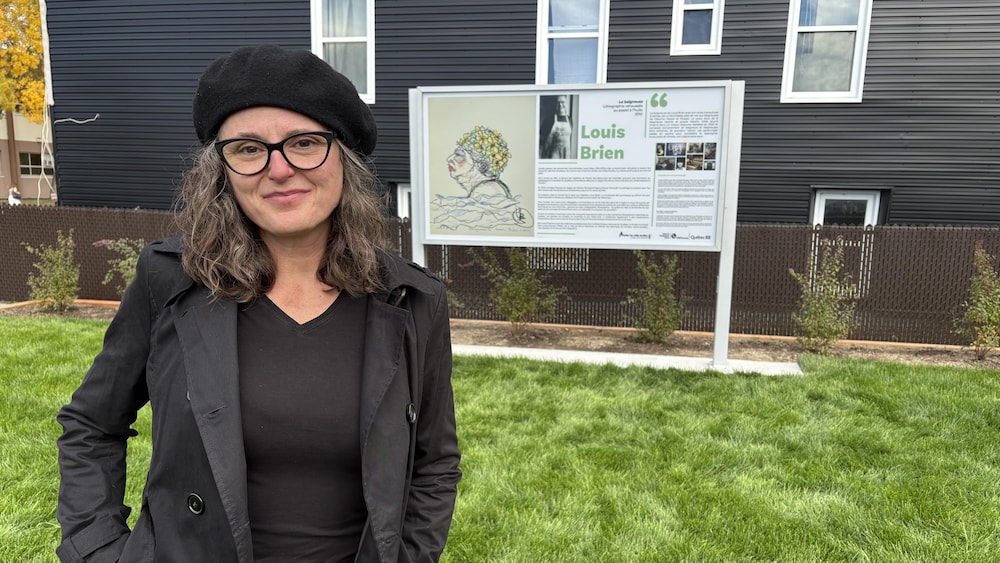 Karine Hébert près d'une œuvre exposée dans un parc.