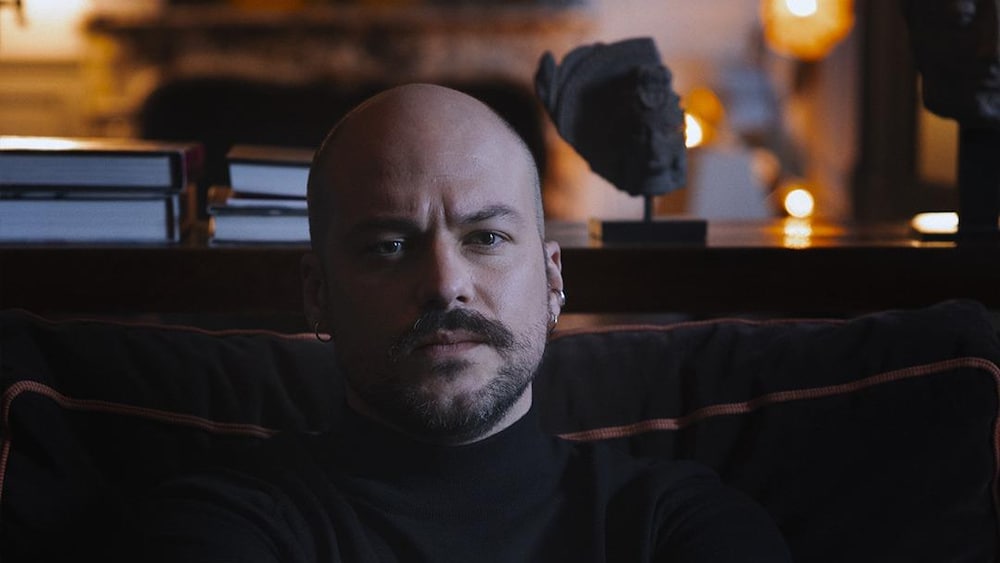 Affiche du film montrant le personnage principal assis sur un sofa et croisant les bras. 