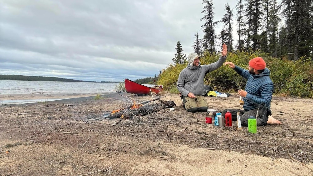 Louis Brassard et Steve Pelletier près d'un feu sur une plage.