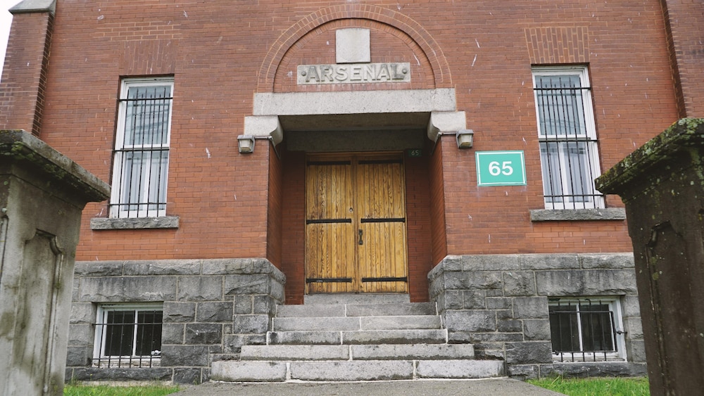 Entrée avant du manège militaire de Rimouski avec ses portes de bois massif et son épigraphe indiquant le nom de l'immeuble «Arsenal».