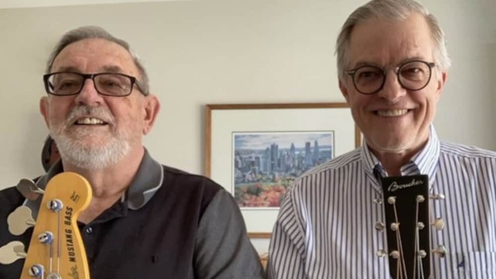 Deux hommes souriants, posent ensemble lors d'une entrevue à distance.