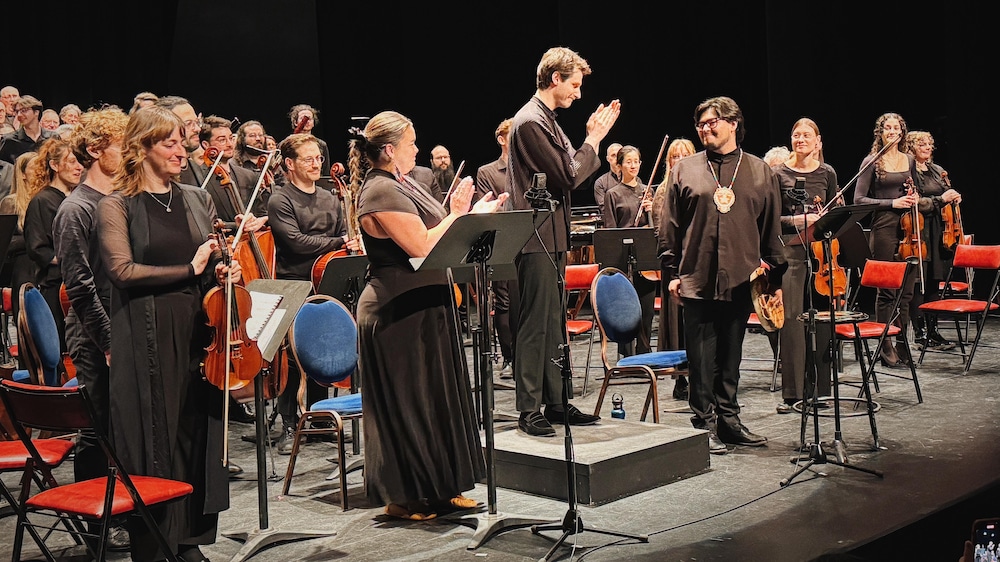 Les solistes Elizabeth St-Gelais et Alexis Vollant, le chef d'orchestre Benoît Gauthier et les musiciens de l'Orchestre symphonique de la Côte-Nord saluent la foule, debout sur scène.