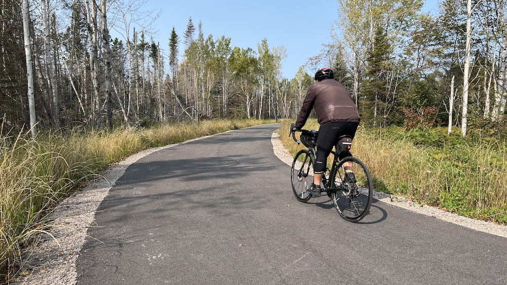 Un cycliste circule sur une piste asphaltée. 