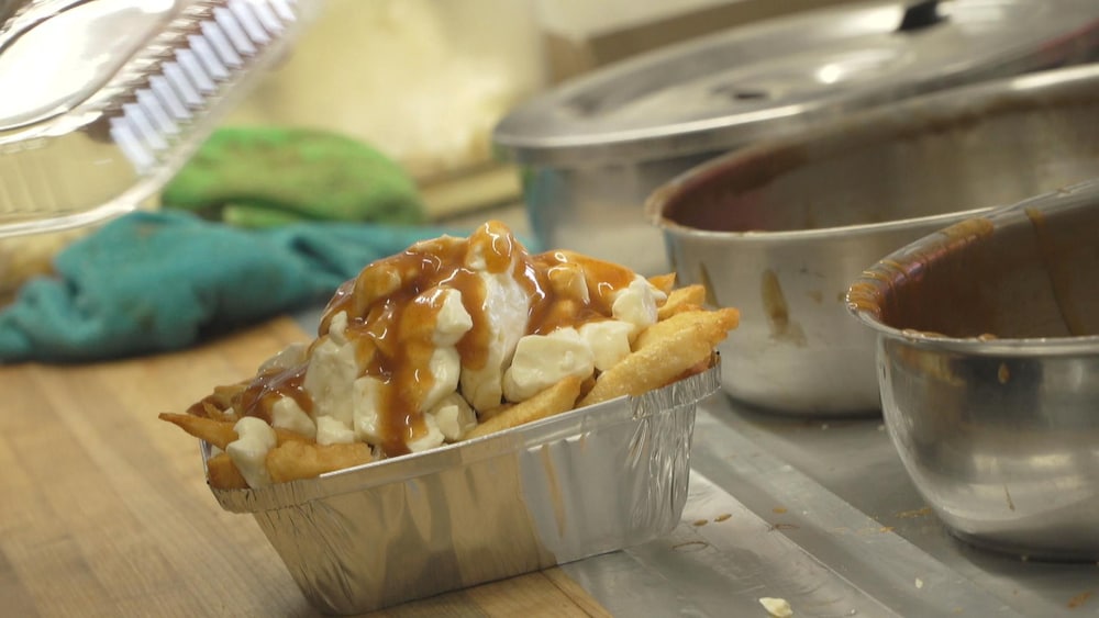 Une poutine sur un comptoir en bois.
