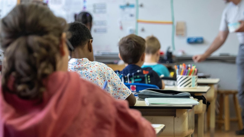 Des élèves assis à leur bureau en classe. 