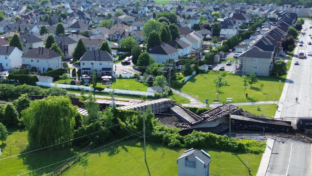 Vue aérienne d'un train qui a déraillé à côté d'un secteur résidentiel.