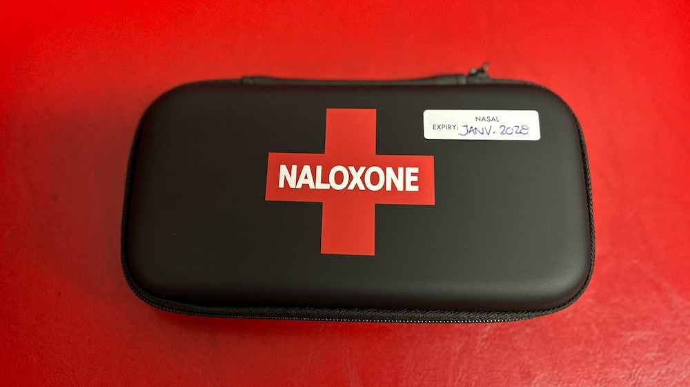 Une trousse de naloxone sur un fond rouge.
