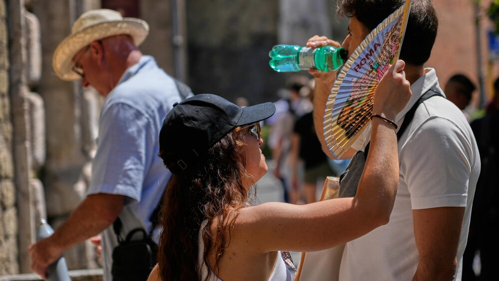 Une femme utilise un éventail pour se rafraîchir.