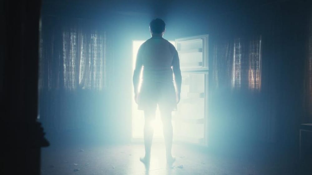 3 Dans un extrait du film, un homme de dos est devant un frigo rempli de lumière.