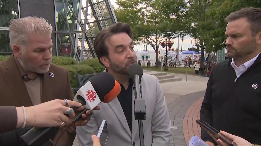 Yohann St-Pierre, candidat du Parti québécois dans Rimouski, parle au micro dans un point de presse avec Paul St-Pierre Plamondon (droite) et Pascal Bérubé (gauche).