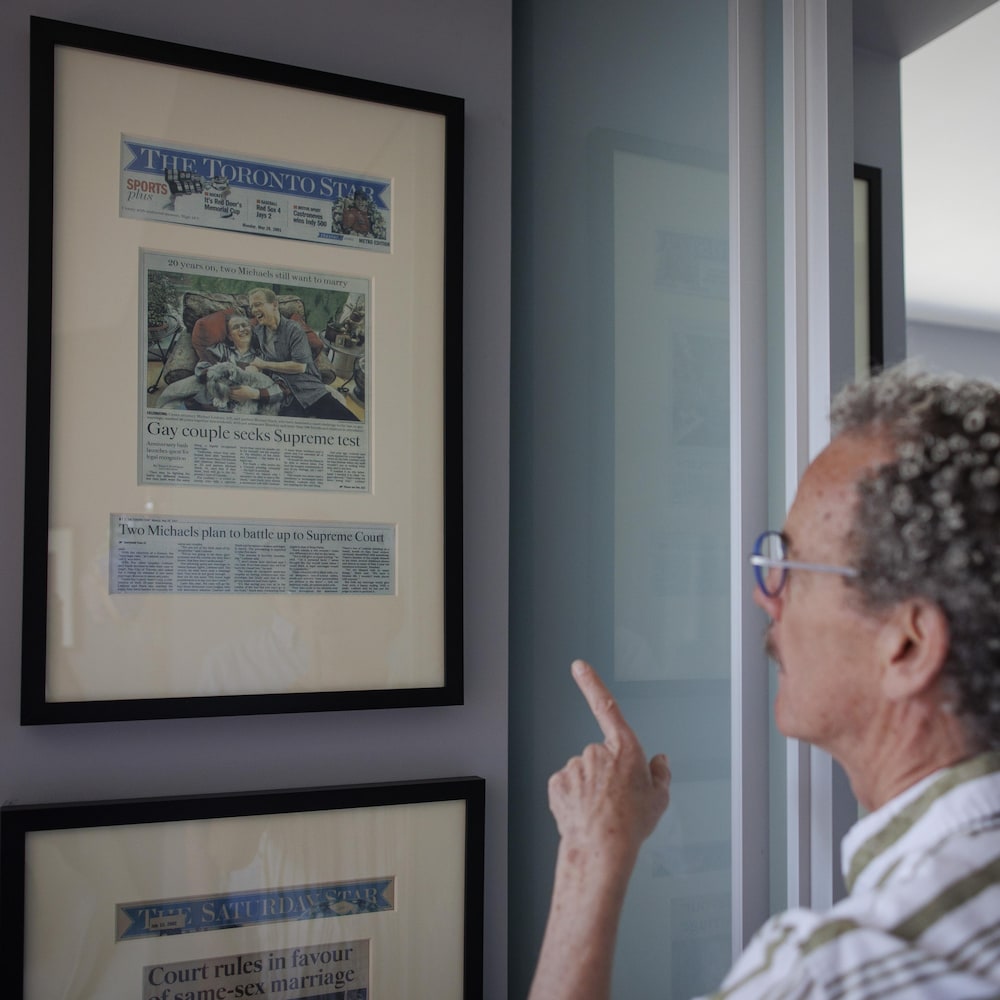 Michael Stark et Michael Leshner regardent des articles de journaux accrochés au mur de leur condo.