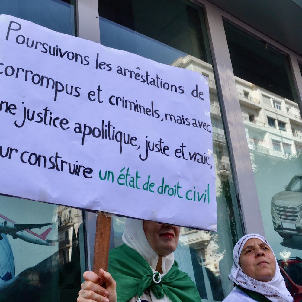 Une femme tient une pancarte réclamant un état de droit civil lors d’une manifestation à Alger en juin 2019