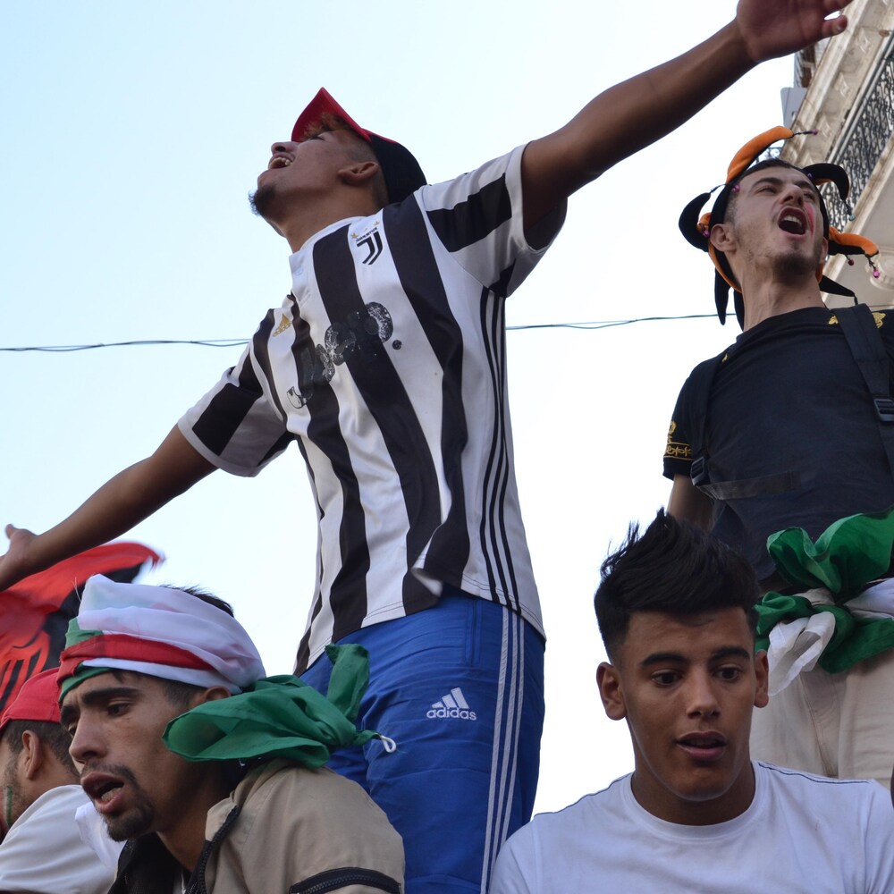 Des jeunes Algériens célèbrent lors d’une manifestation du Hirak à Alger en juin 2019.