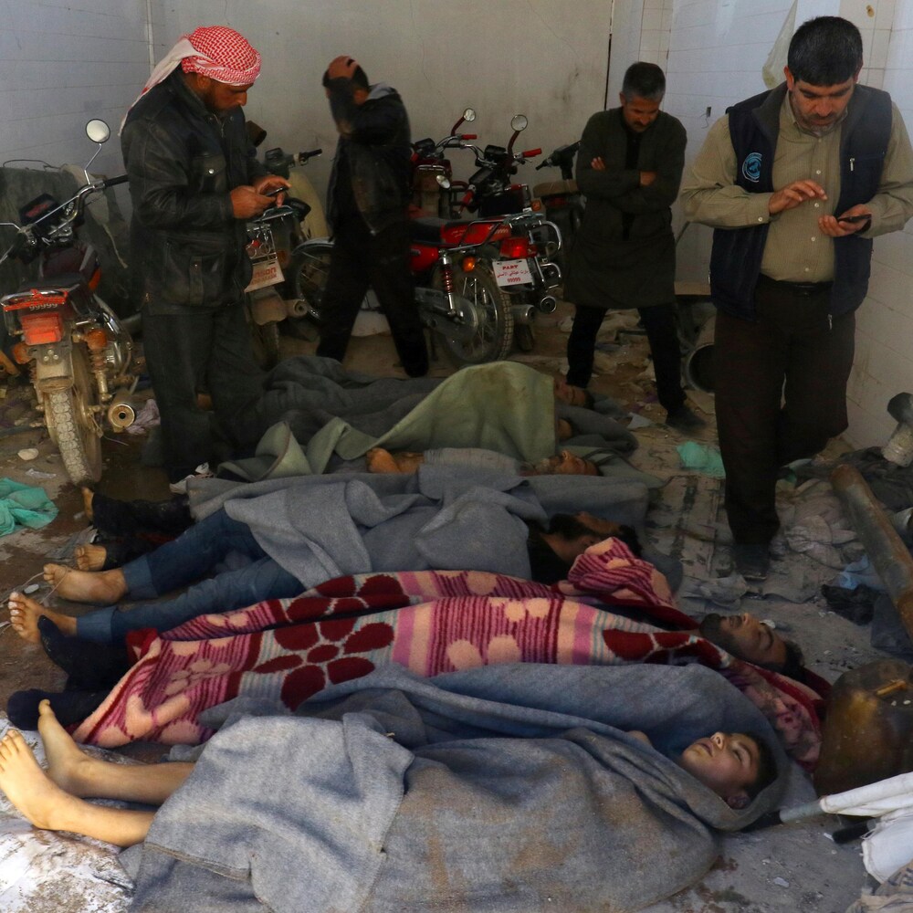 Des hommes se tiennent près des corps de victimes de l’attaque au gaz dans la ville de Khan Sheikhoun, en Syrie, le 4 avril 2017.