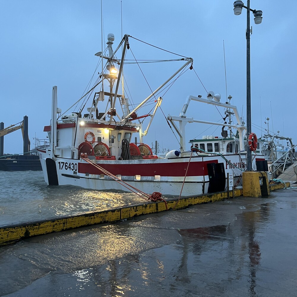 Un bateau de pêche flotte au niveau du quai.