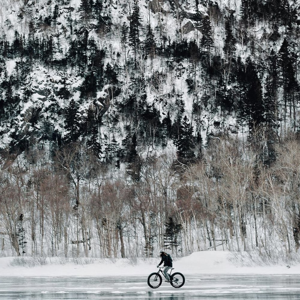 Une personne à vélo sur la glace au Parc national des Hautes Gorges de la rivière Malbaie