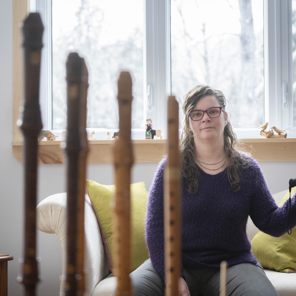 Cécilia Lauenstein avec sa canne dans son salon devant ses flûtes.