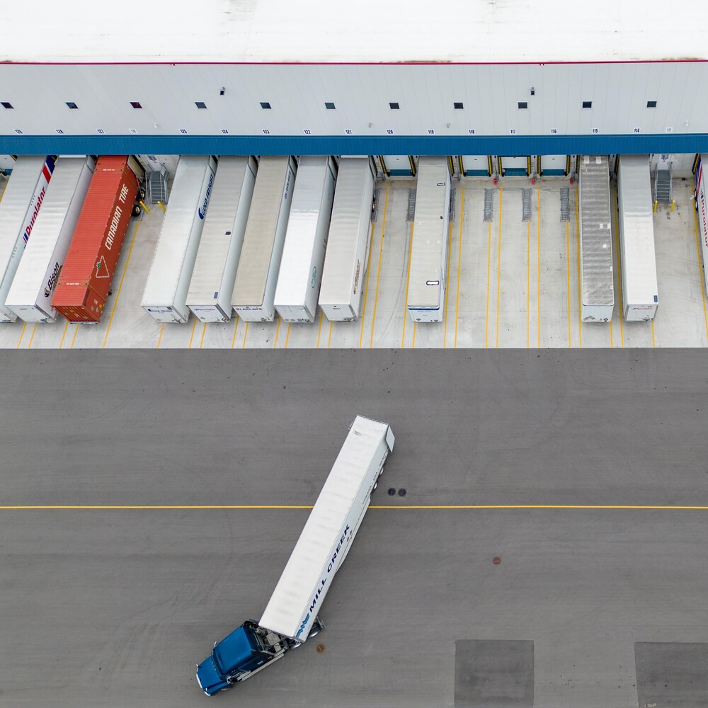 Une vue aérienne du nouveau centre de tri qui montre le stationnement de nombreux camions de livraison.