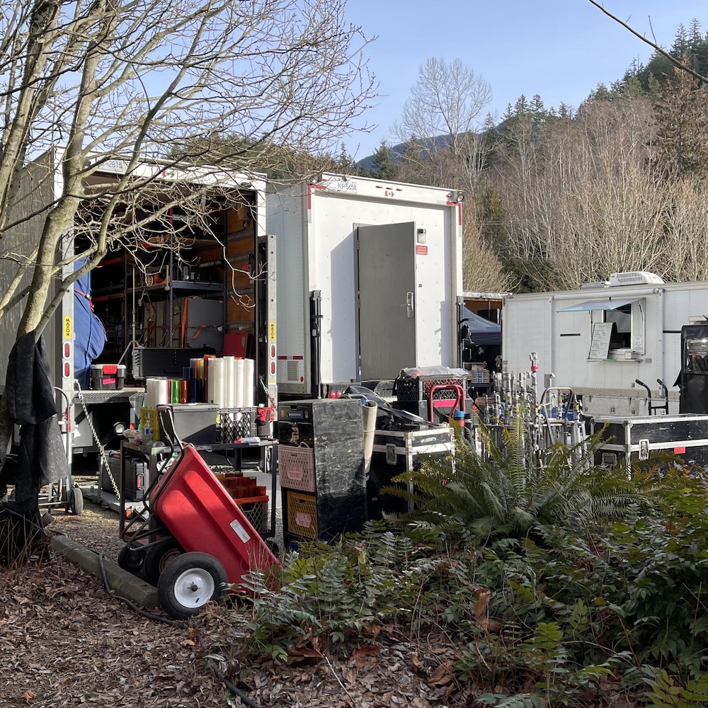 Camions et équipements de tournage dans un seceur boisé en Colombie-Britannique.