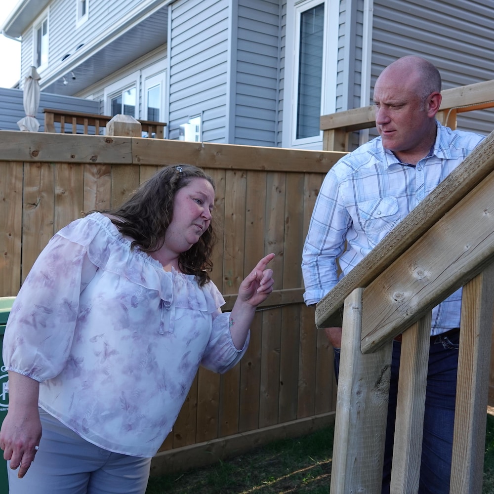 Nicole Favreau montre un défaut de construction à John McKale dans l'escalier de la cour arrière de sa maison.