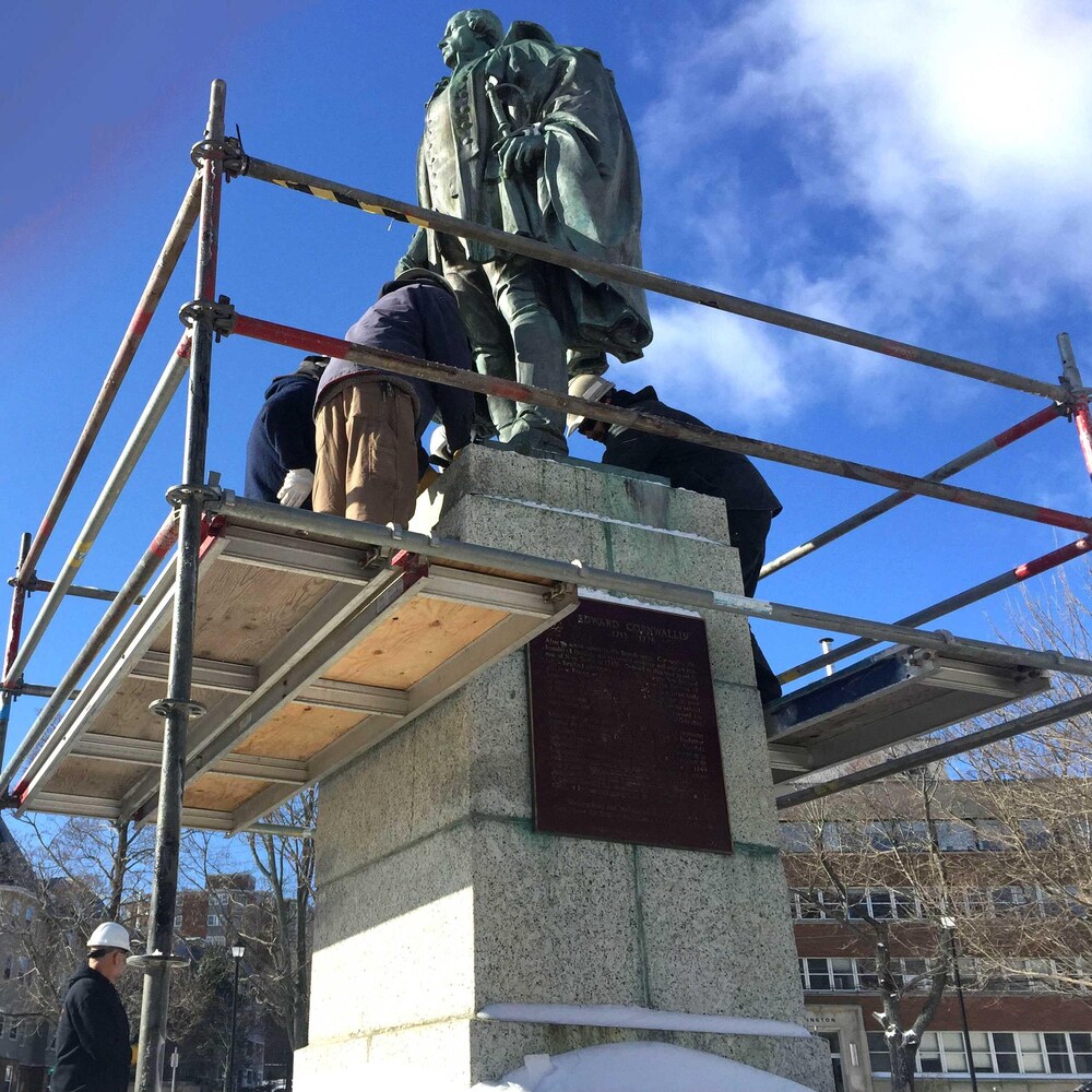 Des travailleurs montent un échafaudage autour de la statue de Cornwallis.