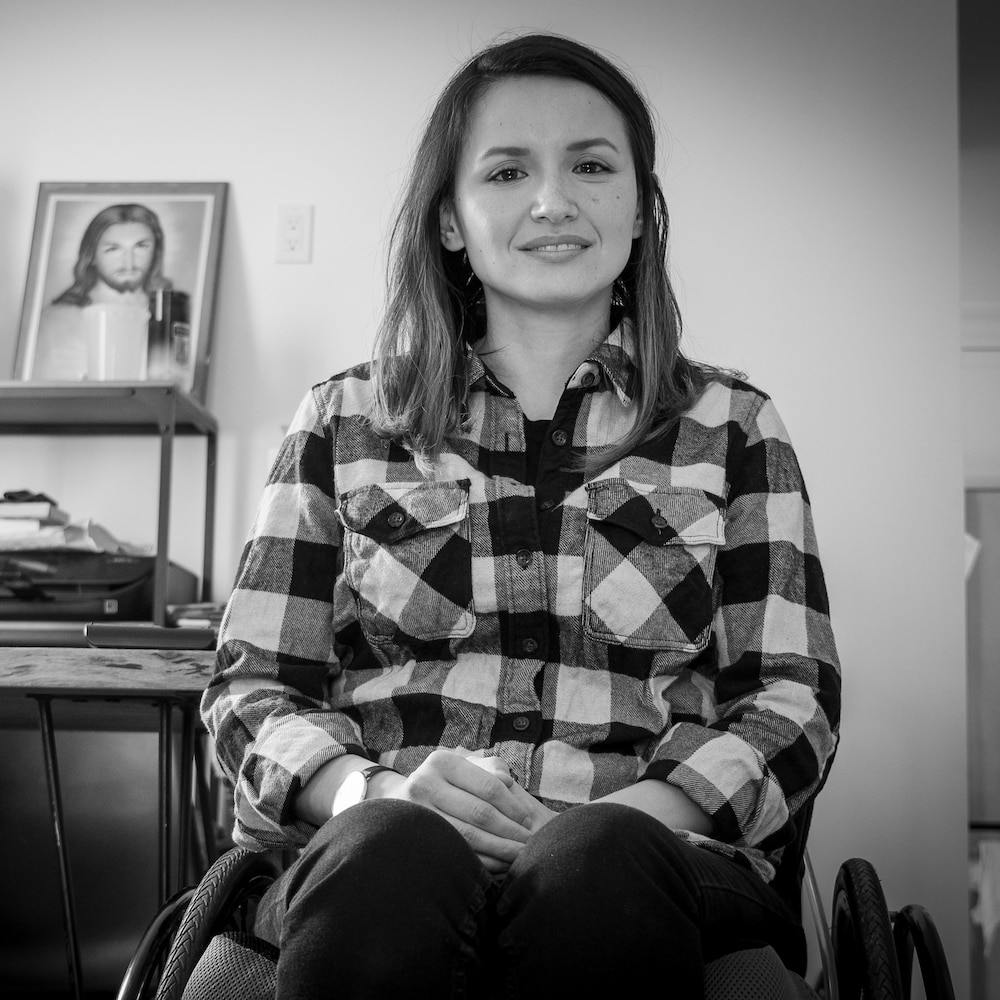 Une femme assisse sur un fauteuil roulant.