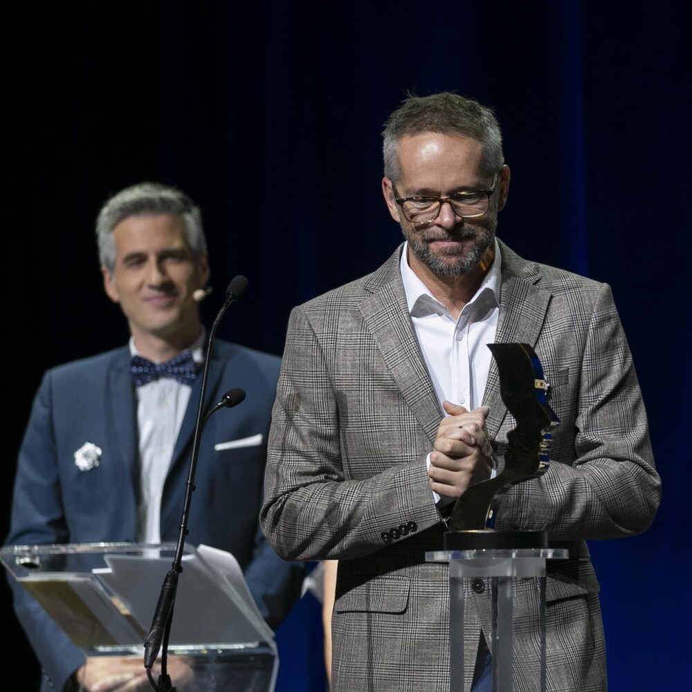 Danny Lemieux avec son trophée Gémeaux, l'animateur Olivier Niquet en arrière plan.